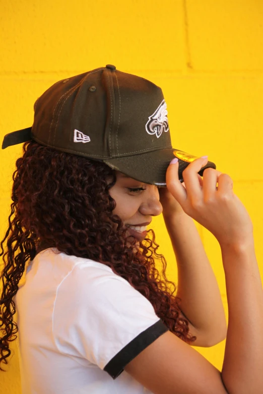 a woman with curly hair wearing a hat, nfl, authentic, low profile, aerodynamic