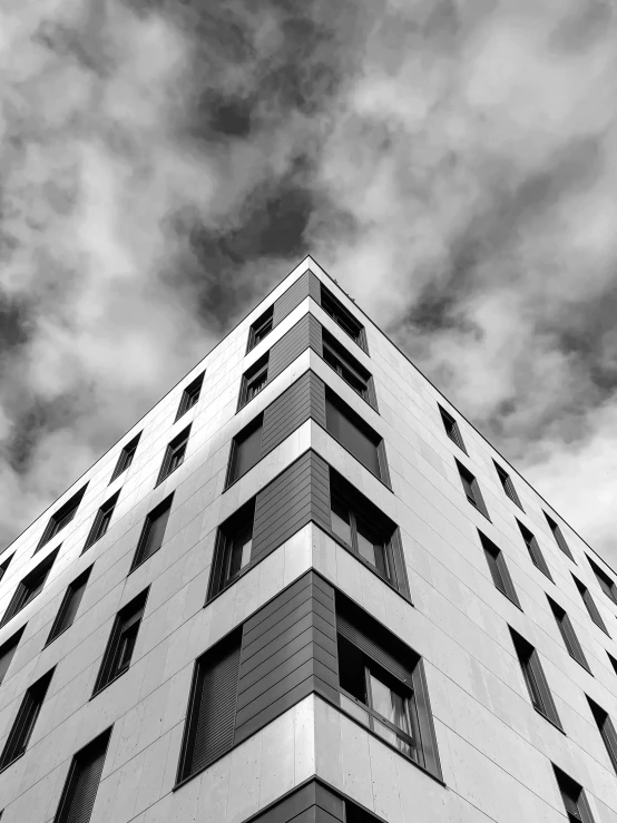 a black and white photo of a tall building, by Bauhaus, unsplash, square, dramatic sky, jovana rikalo, low angle!!!!