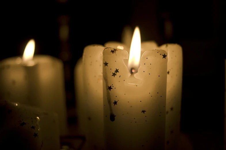 a group of lit candles sitting on top of a table, profile image, digital image