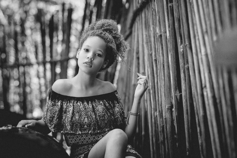 a black and white photo of a woman smoking a cigarette, by Daniel Gelon, pexels, light skinned african young girl, in a bamboo forest, girl with messy bun hairstyle, beautiful little girl