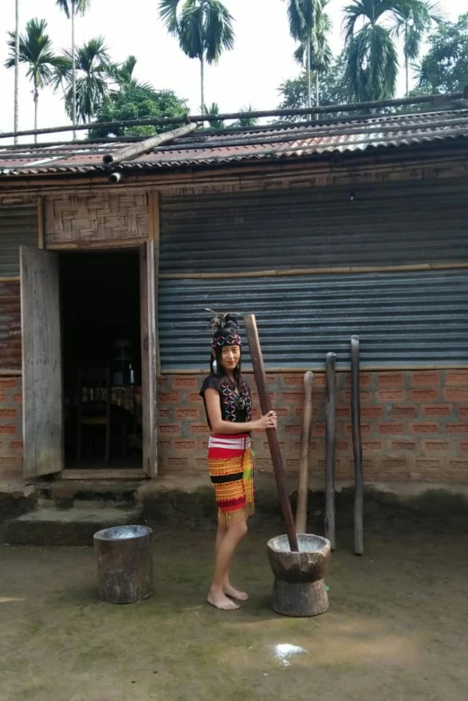 a woman that is standing in front of a building, inspired by Nam Gye-u, sumatraism, drummer, filling with water, standing outside a house, wearing dirty travelling clothes