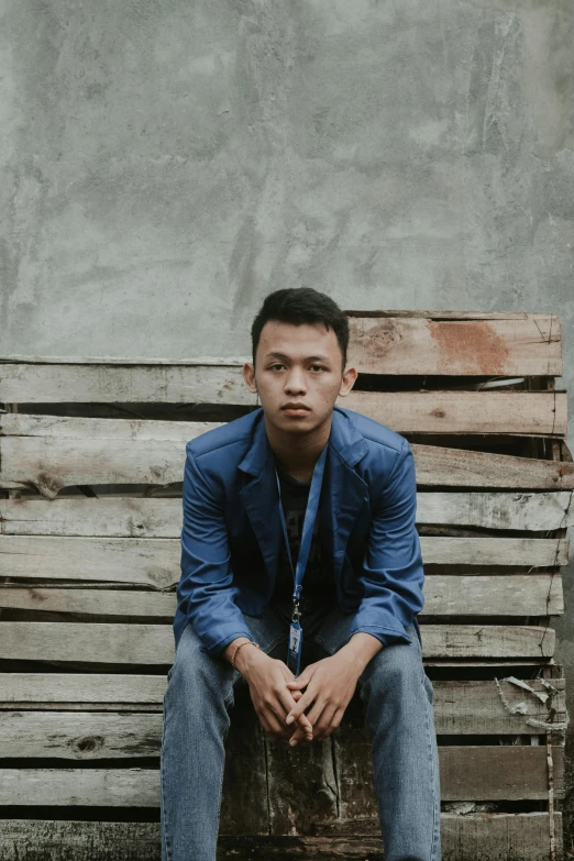 a man sitting on top of a wooden bench, an album cover, inspired by Rudy Siswanto, pexels contest winner, sumatraism, ((portrait)), serious expression, faded, casually dressed