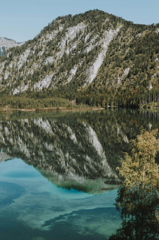 a body of water with a mountain in the background, water mirrored water, green water, alps, van