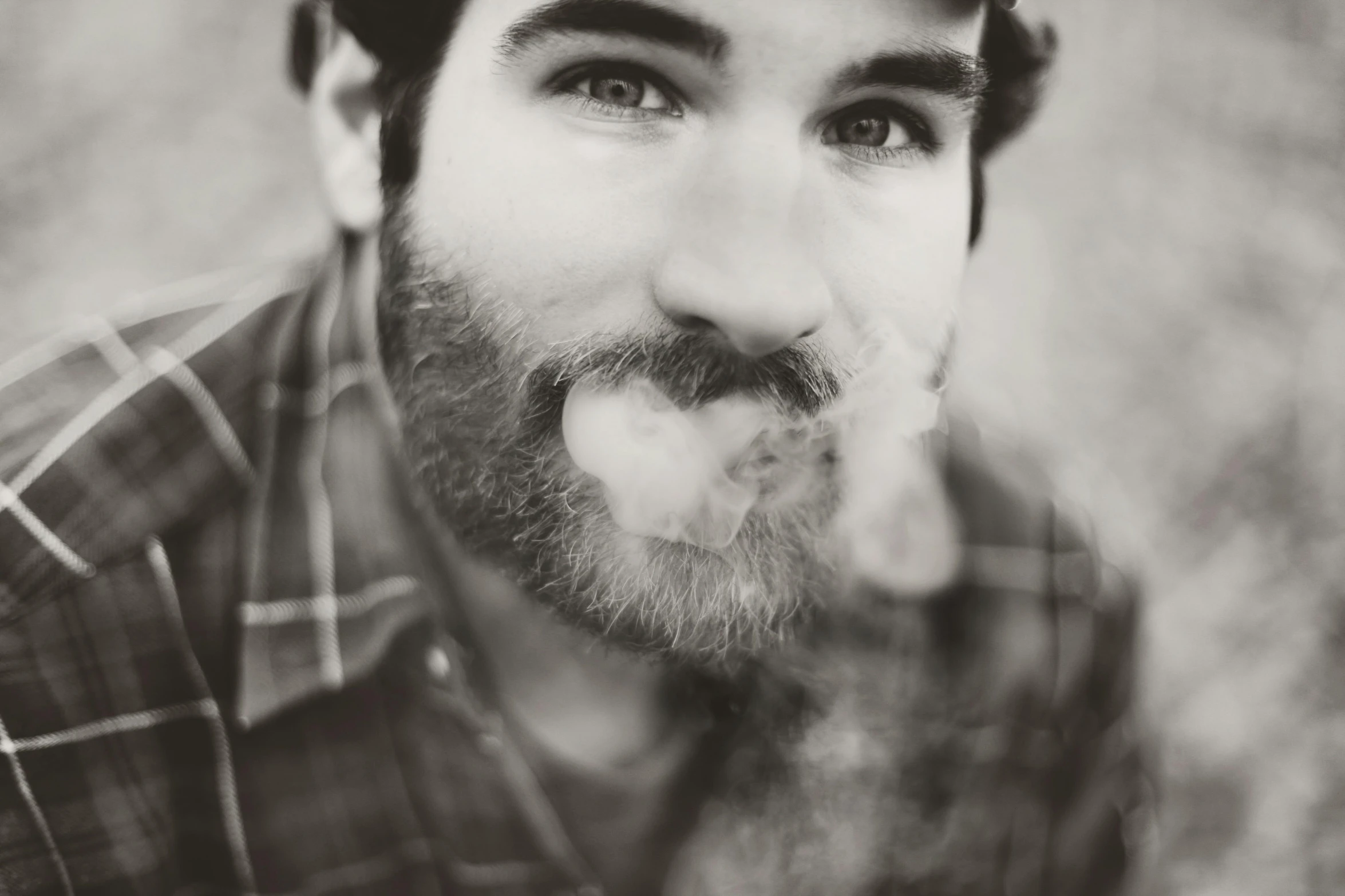 a black and white photo of a man with a beard, a black and white photo, unsplash, conceptual art, smoker, zachary quinto, grainy vintage, portrait close up of guy