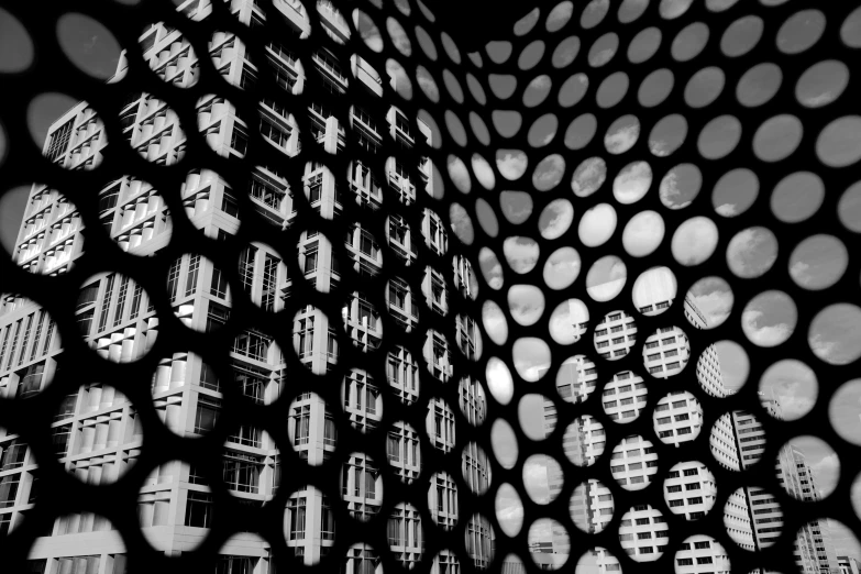 a black and white photo of a large building, a black and white photo, by Louis Schanker, flickr, vorticism, trypophobia, screen space reflections, black round hole, in hong kong