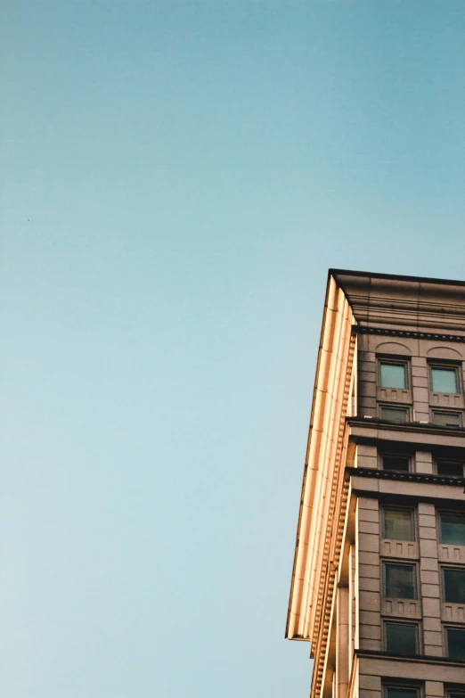 a clock that is on the side of a building, by Andrew Domachowski, unsplash contest winner, neoclassicism, clear sky above, sunfaded, the building is a skyscraper, 2000s photo