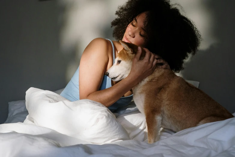 a woman cuddles a dog on a bed, trending on pexels, shibu inu, essence, summer evening, manuka