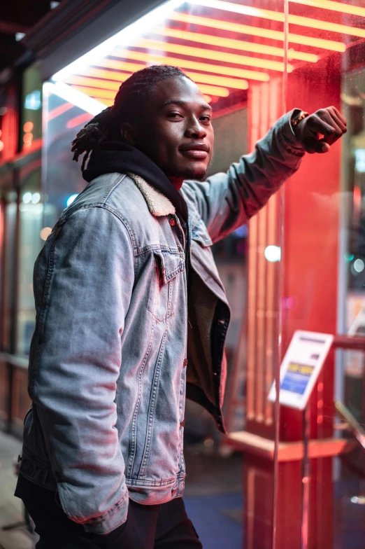 a man with dreadlocks standing in front of a store, an album cover, trending on pexels, hero pose colorful city lighting, red lights, joe keery, riyahd cassiem