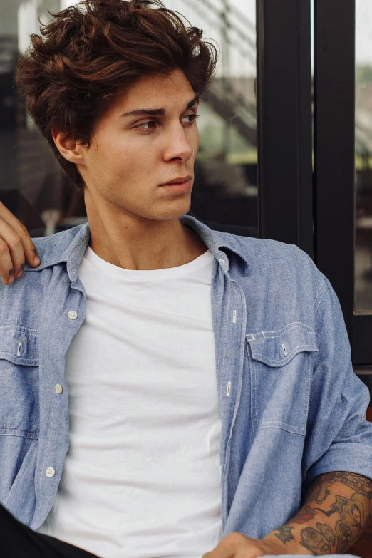 a man sitting on a bench next to a window, a colorized photo, inspired by John Luke, trending on pexels, photorealism, masculine jawline!, wearing double denim, tommy 1 6 years old, wearing a linen shirt