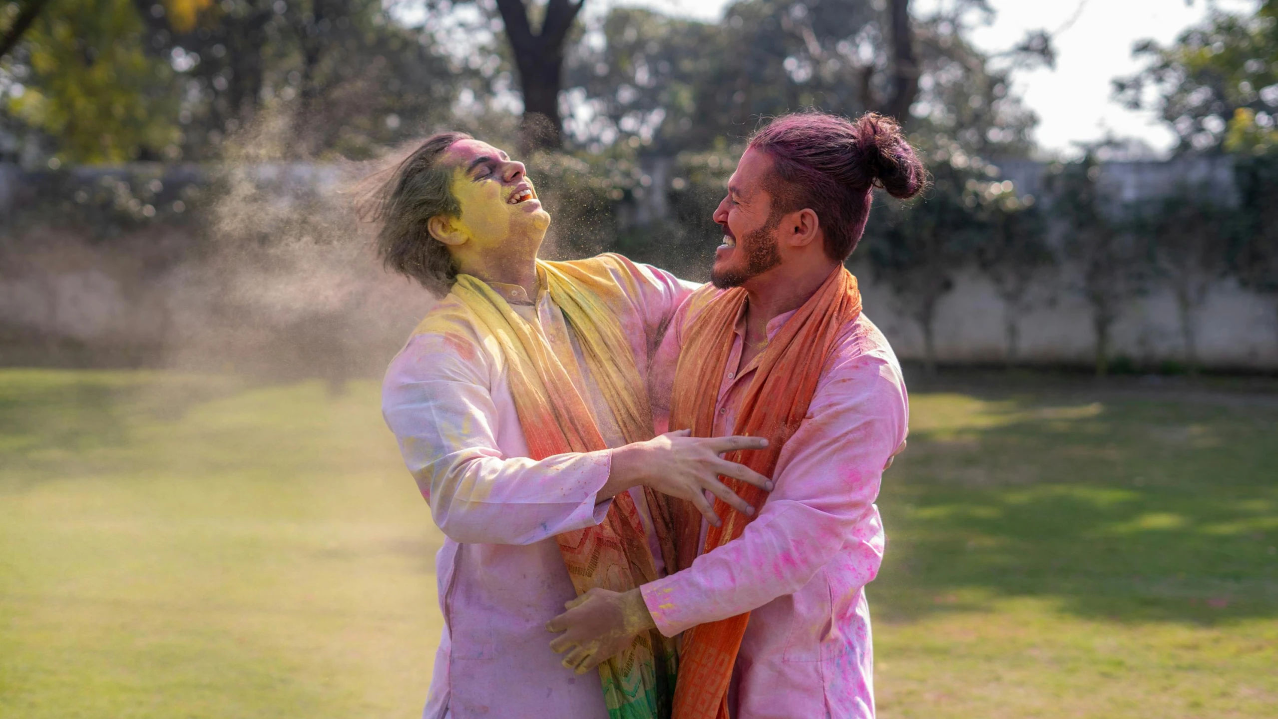 a couple of men standing on top of a lush green field, a colorized photo, pexels contest winner, color field, wearing rainbow kimono, covered in white flour, wearing a kurta, fighting