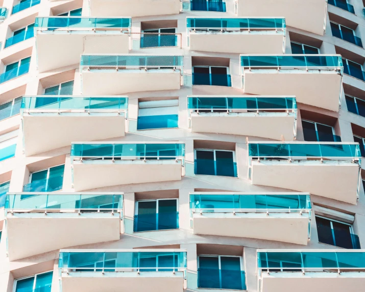 a tall building with lots of windows and balconies, inspired by Ricardo Bofill, pexels contest winner, teal, hotel room, pink white turquoise, photorealist