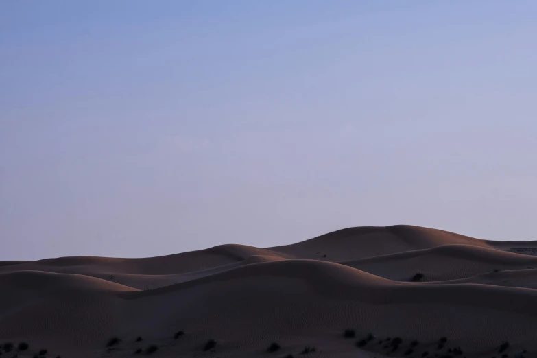 a person is flying a kite in the desert, a picture, unsplash contest winner, hurufiyya, blue hour, slightly minimal, purple sand, seen from afar