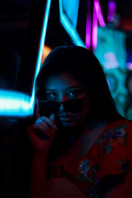 a woman talking on a cell phone in the dark, an album cover, inspired by Elsa Bleda, pexels contest winner, holography, sunglasses, asian girl, nightlife, driving