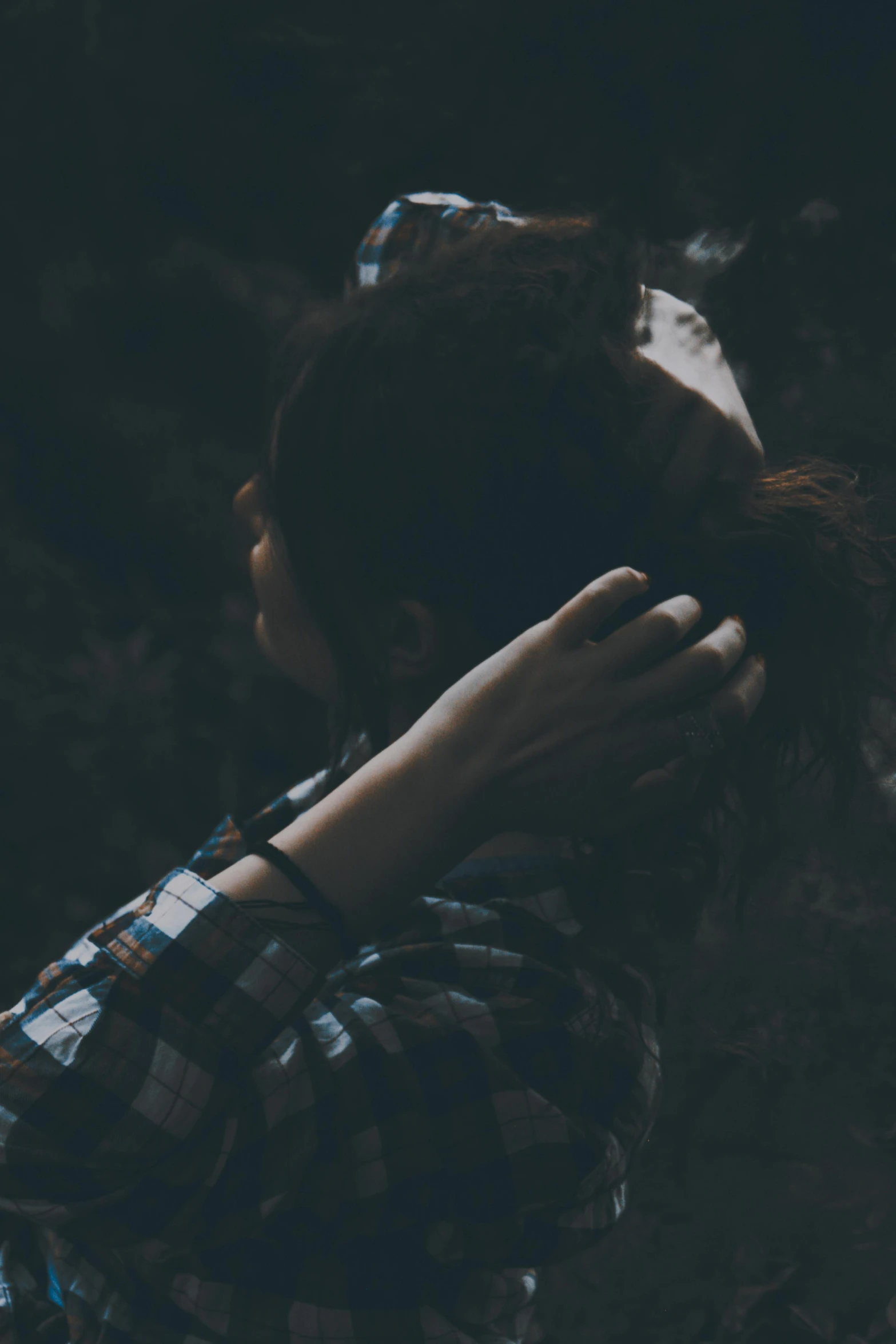 a woman covering her face with her hands, inspired by Elsa Bleda, trending on pexels, romanticism, braided hair. nightime, arm around her neck, listening to music, lost in a cave