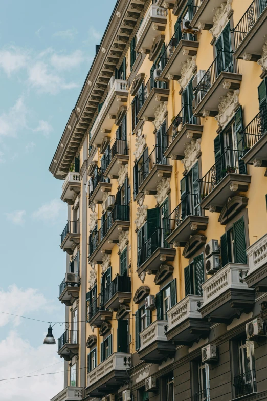 a couple of buildings that are next to each other, pexels contest winner, neoclassicism, yellow and greens, apartments, italian style, high rise buildings