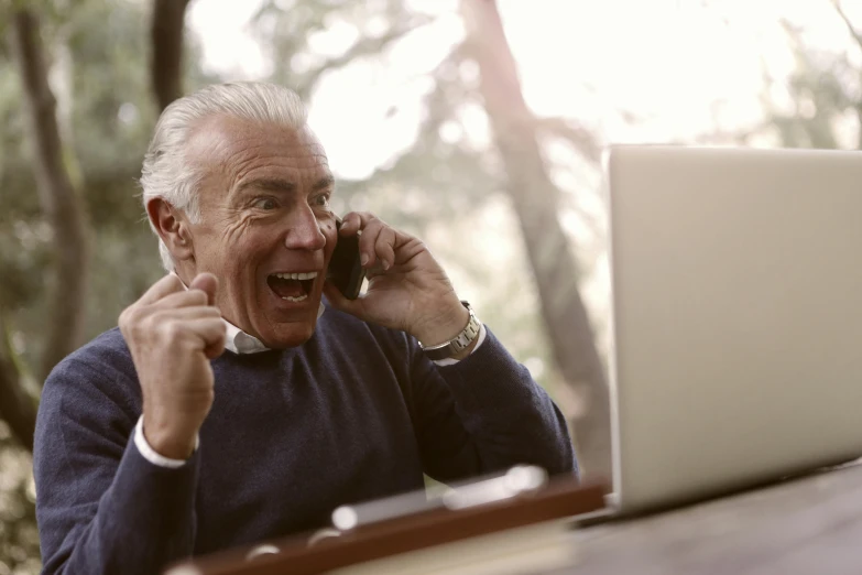 a man sitting in front of a laptop talking on a cell phone, by Gavin Nolan, pexels contest winner, old lady screaming and laughing, ric flair, a wooden, 15081959 21121991 01012000 4k