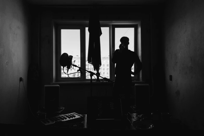 a man that is standing in front of a window, by andrei riabovitchev, microphone silluette, apartment of an art student, musicians, in her room