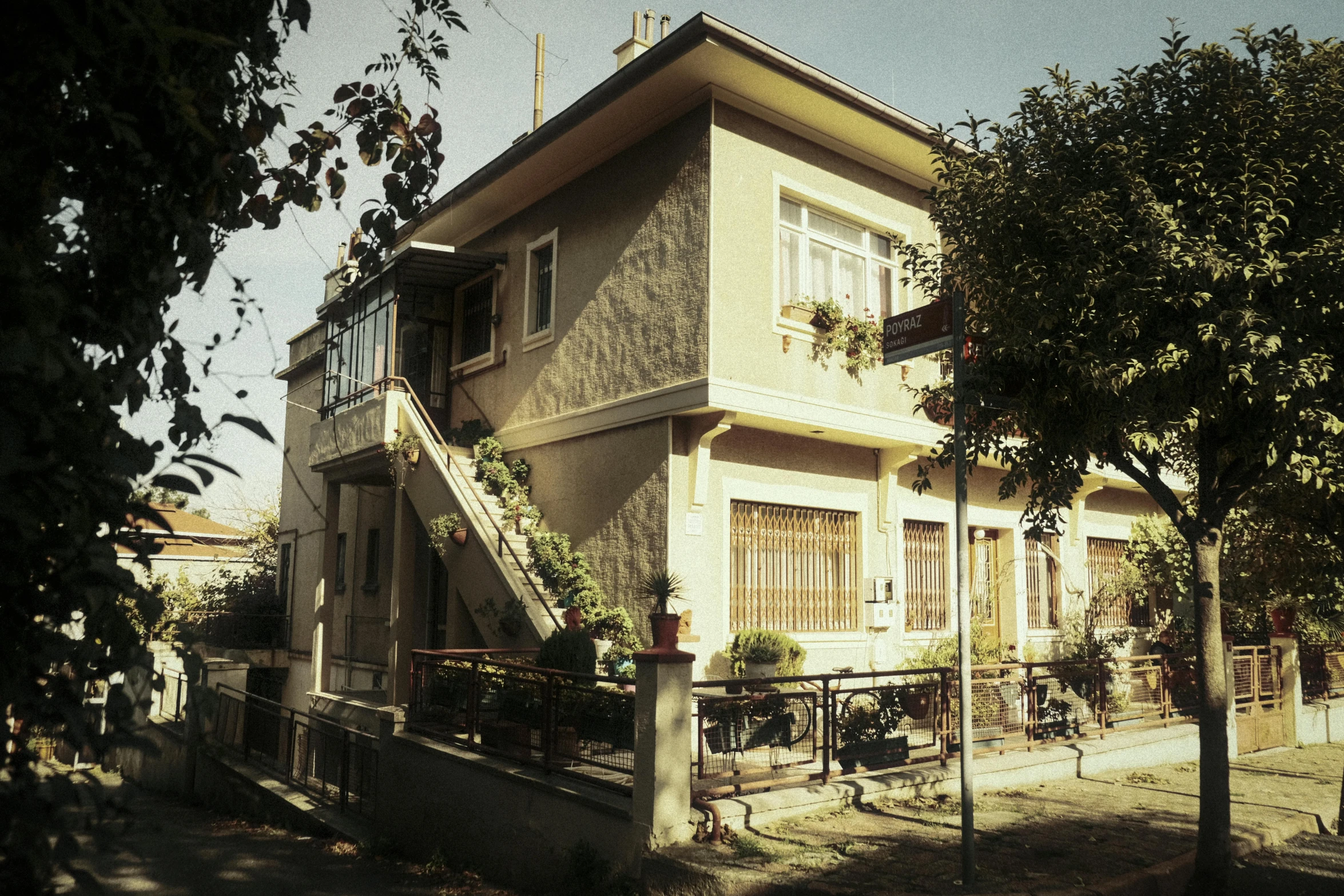 a house with a staircase going up the side of it, by Edward Avedisian, instagram, yellowed with age, fallout style istanbul, full front view, passive house