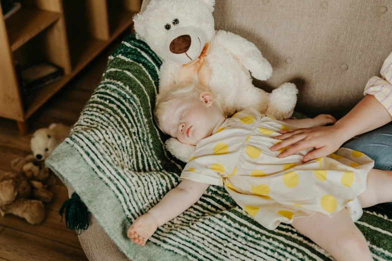 a baby laying on a couch next to a teddy bear, by Julia Pishtar, charli bowater and artgeem, bedhead, carefully crafted, asriel dreemurr
