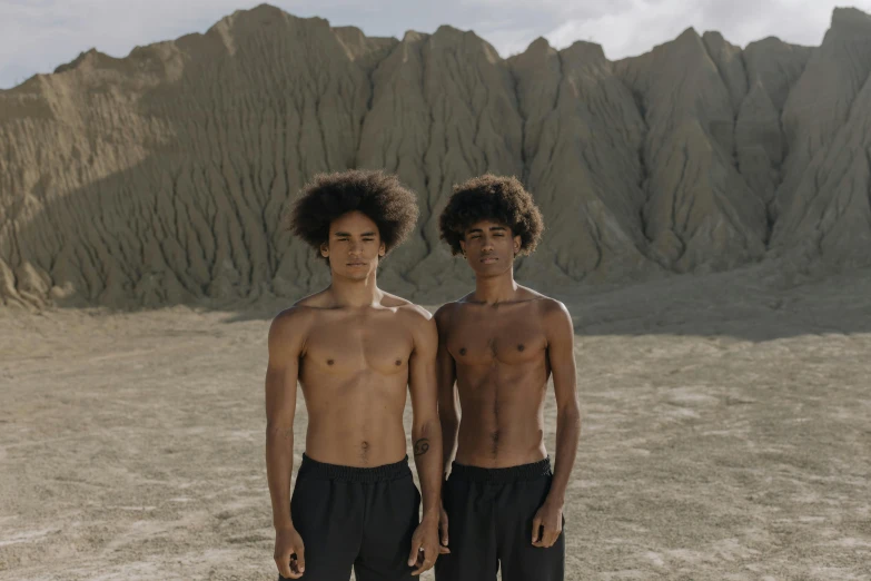 a couple of young men standing next to each other, by Alison Geissler, pexels contest winner, renaissance, brown skin like soil, scene from dune 2 0 2 1 movie, physical : tinyest midriff ever, 14 yo berber boy