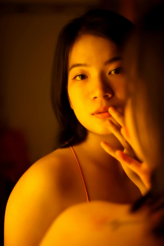 a woman looking at her reflection in a mirror, by David Diao, soft backlight, ((portrait)), orange, asian
