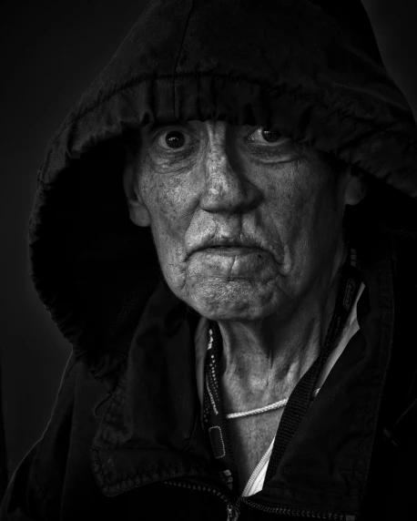 a black and white photo of a man in a hoodie, inspired by Lee Jeffries, an old lady with red skin, concerned, an old lady, taken in 2 0 2 0