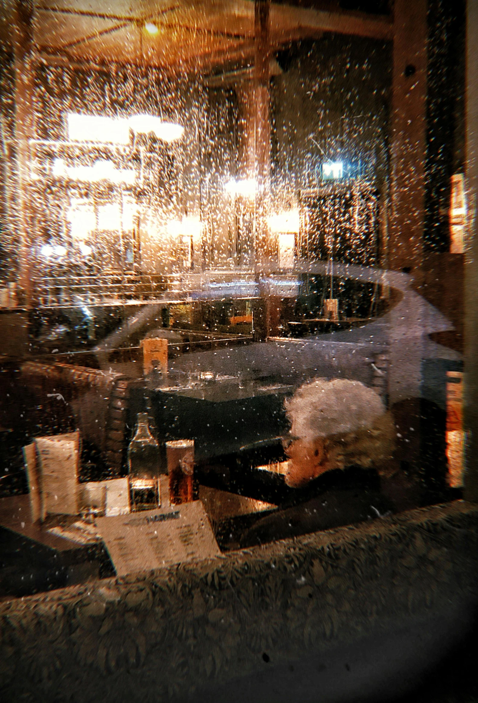 a person sitting at a table in front of a window, inspired by Bruce Davidson, pexels contest winner, rainy evening, busy restaurant, liquid gold, winter storm