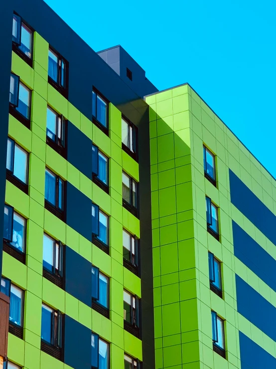 a green and black building with lots of windows, by Washington Allston, unsplash, modernism, chartreuse and orange and cyan, thumbnail, apartment, metal panels