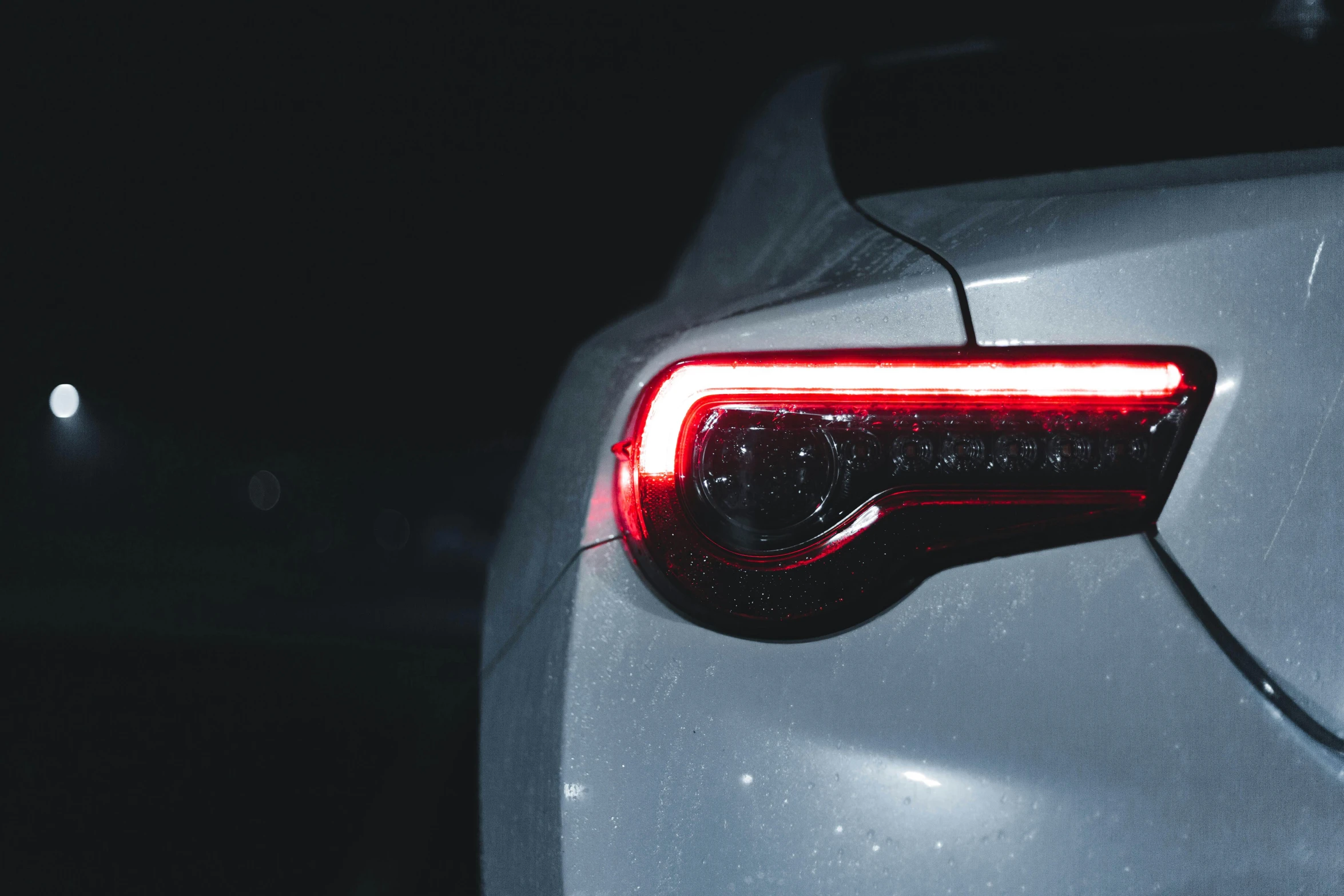 a close up of the tail lights of a car, inspired by Elsa Bleda, pexels contest winner, renaissance, on a gray background, toyota supra, late night, instagram post