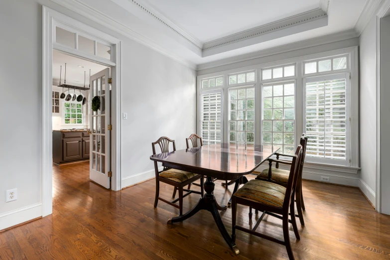 a dining room with a wooden table and chairs, inspired by William Home Lizars, unsplash contest winner, french door window, washington dc, ceiling hides in the dark, colonial style