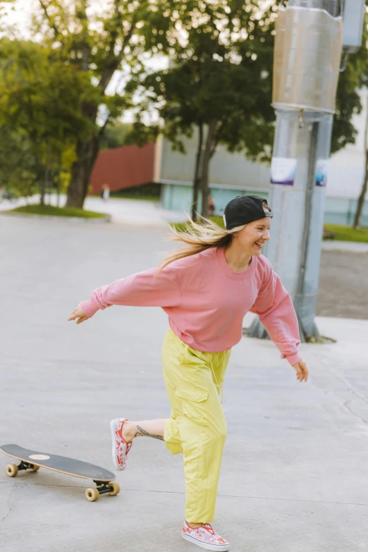 a young girl riding a skateboard down a sidewalk, pexels contest winner, happening, pink clothes, yellow cap, infp young woman, baggy pants