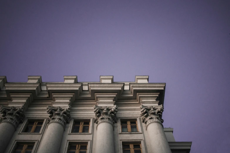 a tall building with a clock on top of it, inspired by Mihály Munkácsy, pexels contest winner, neoclassicism, purple tubes, classical stone columns, view from bottom, mansion
