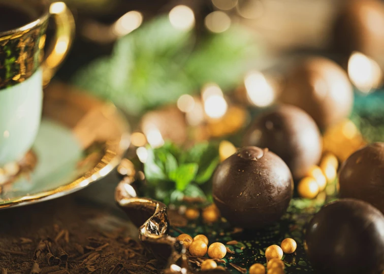 a cup and saucer sitting on top of a table, cannonballs, gold decorations, thumbnail, chocolate