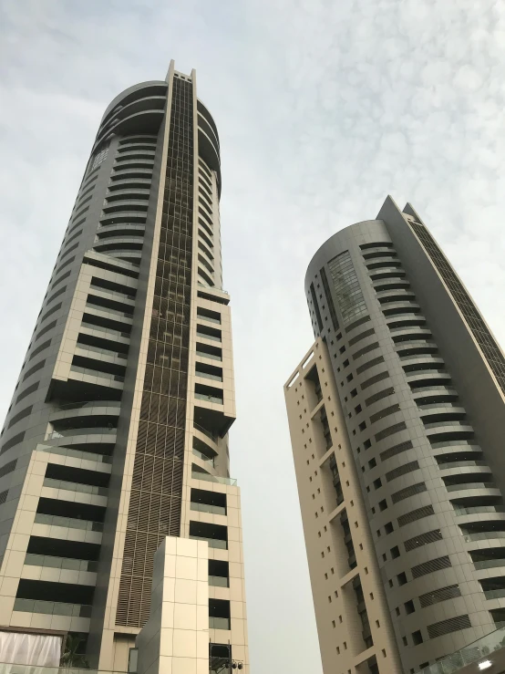 a couple of tall buildings next to each other, brutalism, in egypt, low quality photo, grey, 8k ”