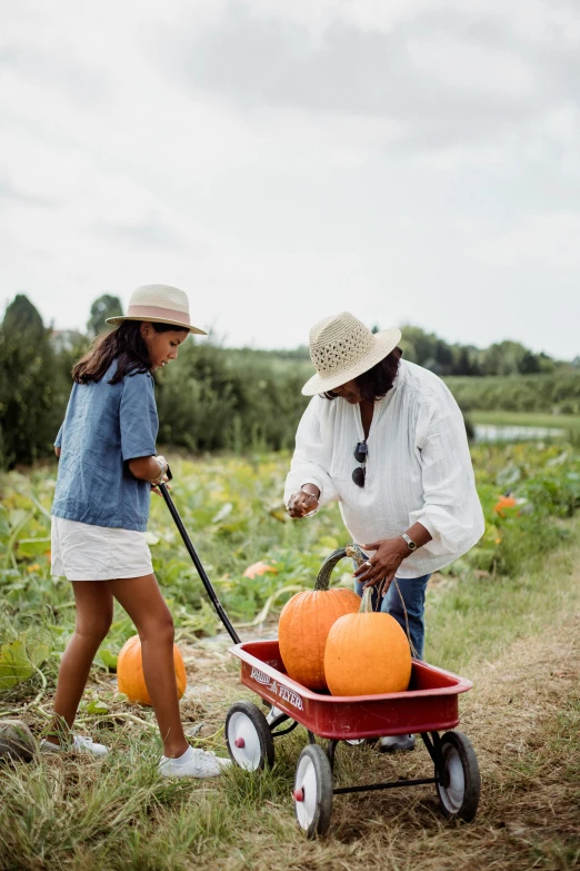 a woman pulling a wagon filled with pumpkins, trending on unsplash, process art, conde nast traveler photo, kids talking to fruit people, thumbnail, on a farm