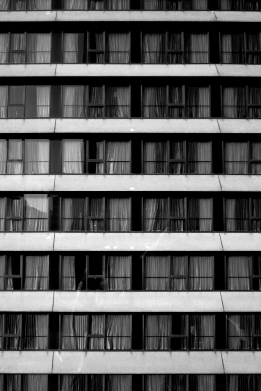 a black and white photo of a tall building, a black and white photo, inspired by Andreas Gursky, unsplash, brutalism, hotel room, house windows, square shapes, balcony
