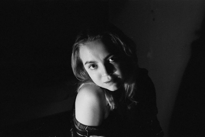 a black and white photo of a woman, by Kati Horna, kiernan shipka, taken on a 1990s camera, underexposed lighting, britt marling style
