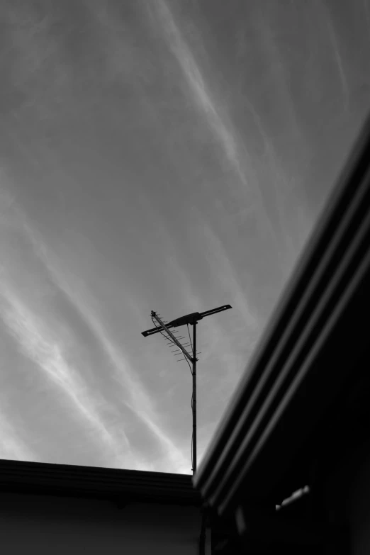 a black and white photo of a tv antenna, inspired by Arnold Newman, taken at golden hour, parking lot, creepy skies, ansel ]