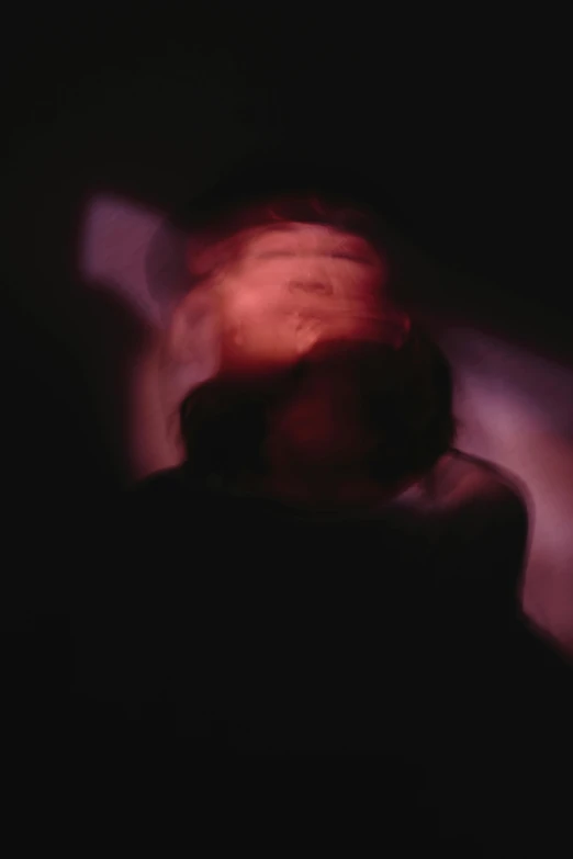 a blurry image of a person in the dark, inspired by Anna Füssli, conceptual art, barely lit warm violet red light, ignant, astral projection, 1960s color photograph