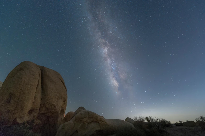 a large rock sitting in the middle of a desert, by Ryan Pancoast, unsplash contest winner, mushrooms milky way, panoramic, boulders, taken through a telescope