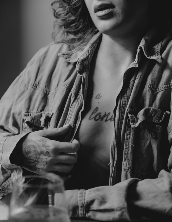 a black and white photo of a woman with a tattoo on her chest, a black and white photo, by Andrée Ruellan, trending on pexels, art photography, jean jacket, cinematic. by leng jun, clothed!! lucien levy - dhurmer, vintage color