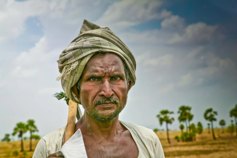 a man in a turban holding a wooden stick, a portrait, by Scott M. Fischer, pexels contest winner, farmland, avatar image