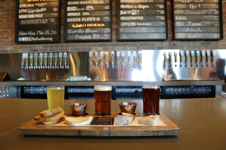 a couple of glasses of beer sitting on top of a counter, bread, flight, multiple stories, colorado