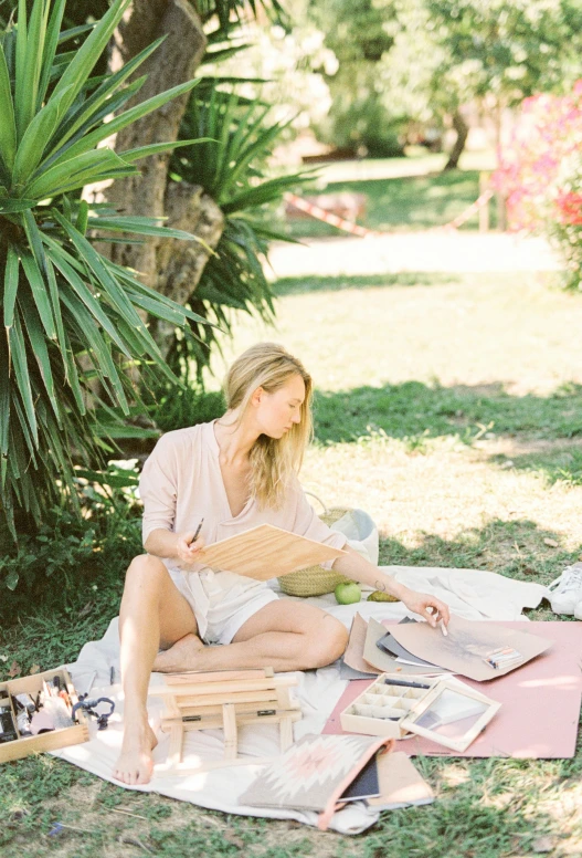 a woman sitting on a blanket reading a book, a picture, having a picnic, giorgia meloni, botanical herbarium paper, in garden