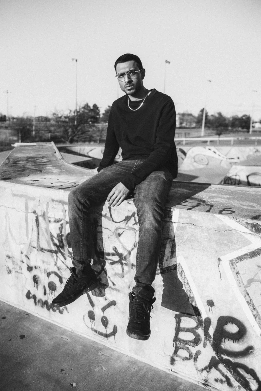 a man sitting on top of a cement wall, an album cover, playboi carti, albuquerque, syd, portait image