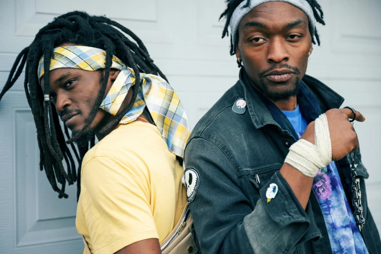 a couple of men standing next to each other, trending on pexels, black arts movement, bandanas, space dandy style, ripped clothing, dreads