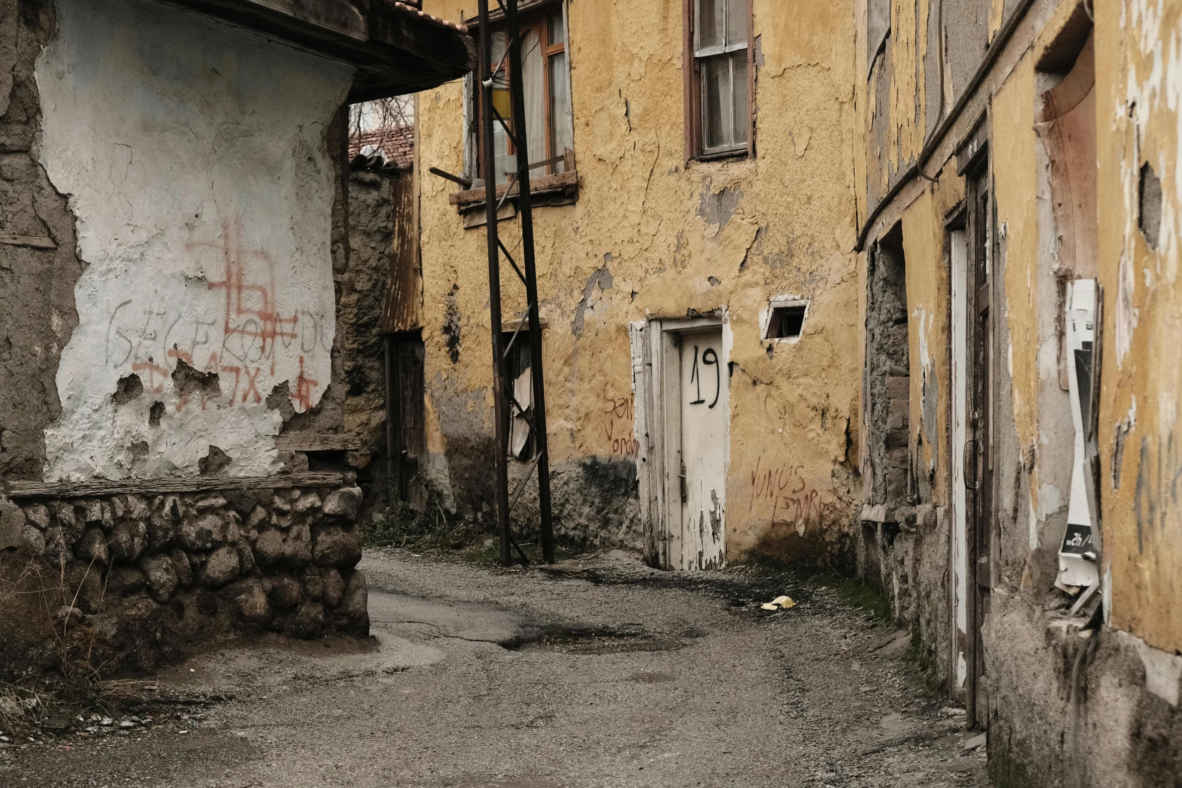 a red fire hydrant sitting on the side of a road, by Muggur, pexels contest winner, graffiti, mud and brick houses, turkey, old color photograph, background image