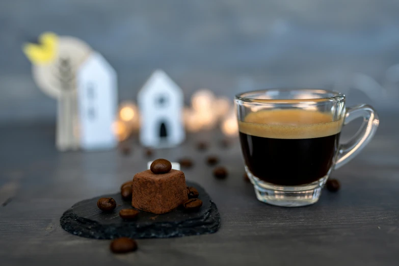 a cup of coffee and some cookies on a table, by Julia Pishtar, pexels contest winner, renaissance, tiny village, lit. 'the cube', small square glasses, black house