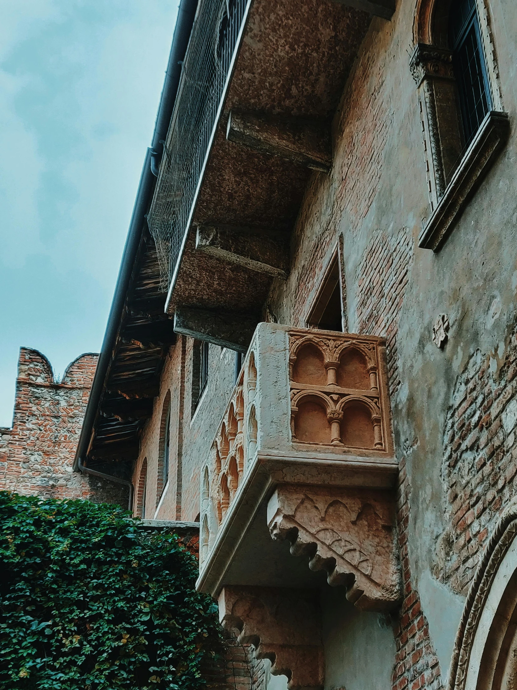 a red fire hydrant sitting in front of a brick building, inspired by Eliseu Visconti, pexels contest winner, renaissance, in balcony of palace, pointed arches, thumbnail, 1 5 6 6