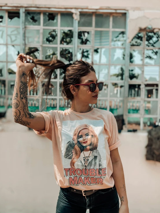 a woman standing on a skateboard in front of a building, a polaroid photo, by Robbie Trevino, trending on pexels, tattooed face, in shades of peach, wearing a marijuana t - shirt, amouranth as a super villain